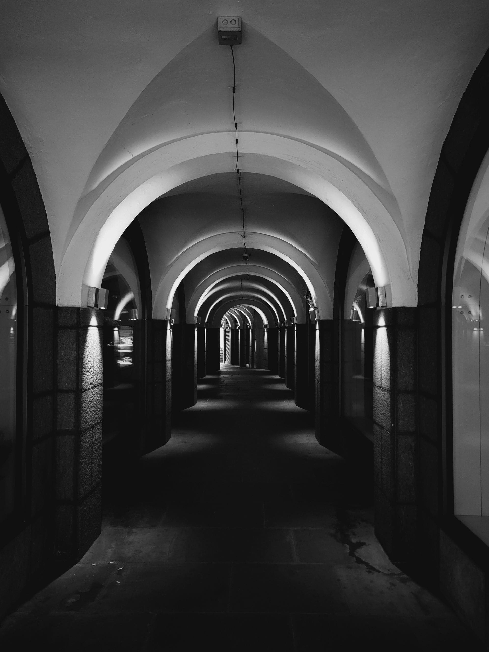 A long arched corridor in London receding into darkness.