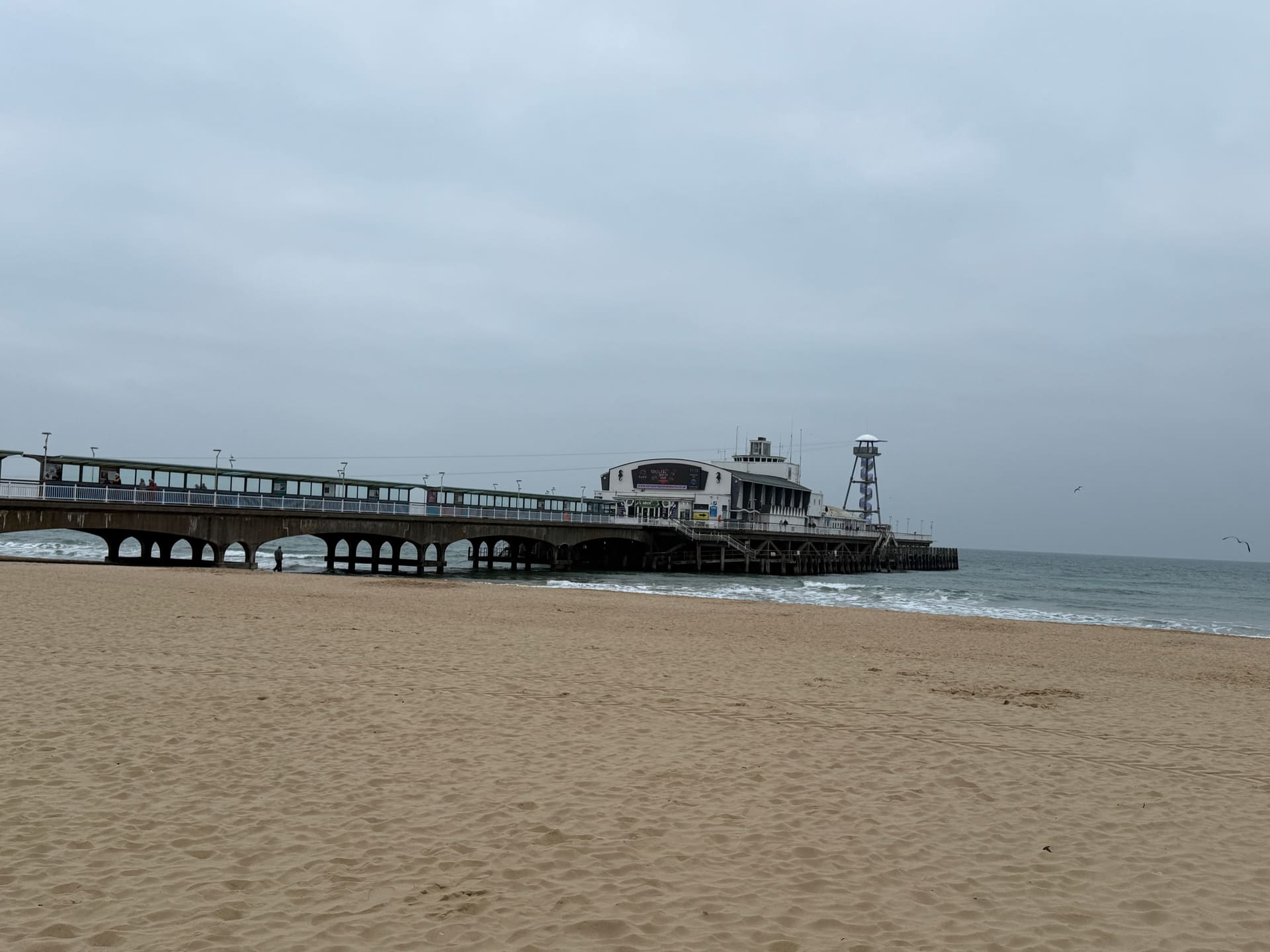 Bournemouth Pier reaching into a grey sea from an empty beach.