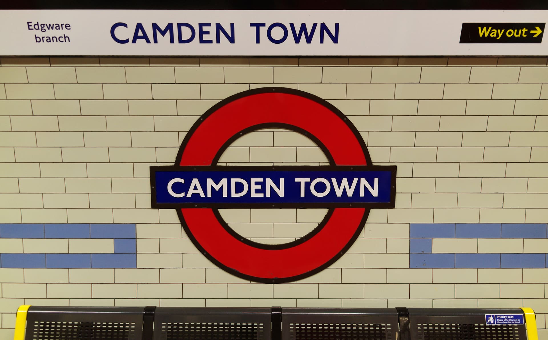 The tiled Camden Town roundel on a tube platform wall.