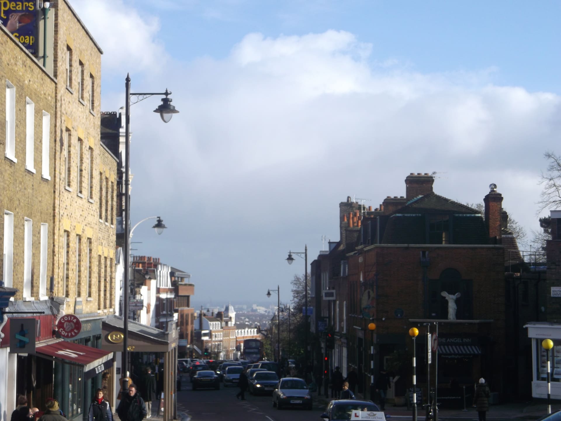 Highgate High Street dropping towards the London skyline under an evening sky.
