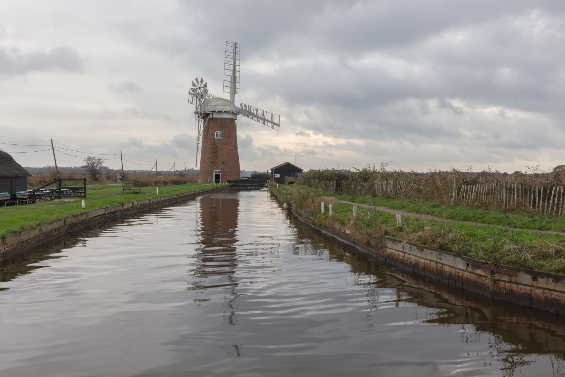 Horsey Windpump reflected in the dyke under a heavy Broads sky.