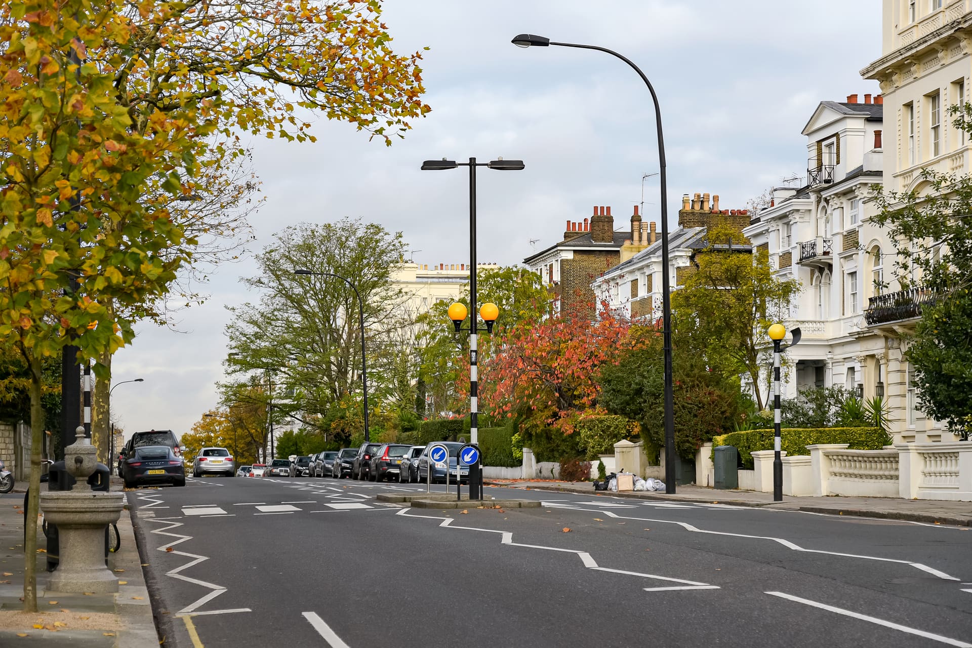 Stucco villas behind autumn trees on a Notting Hill avenue.