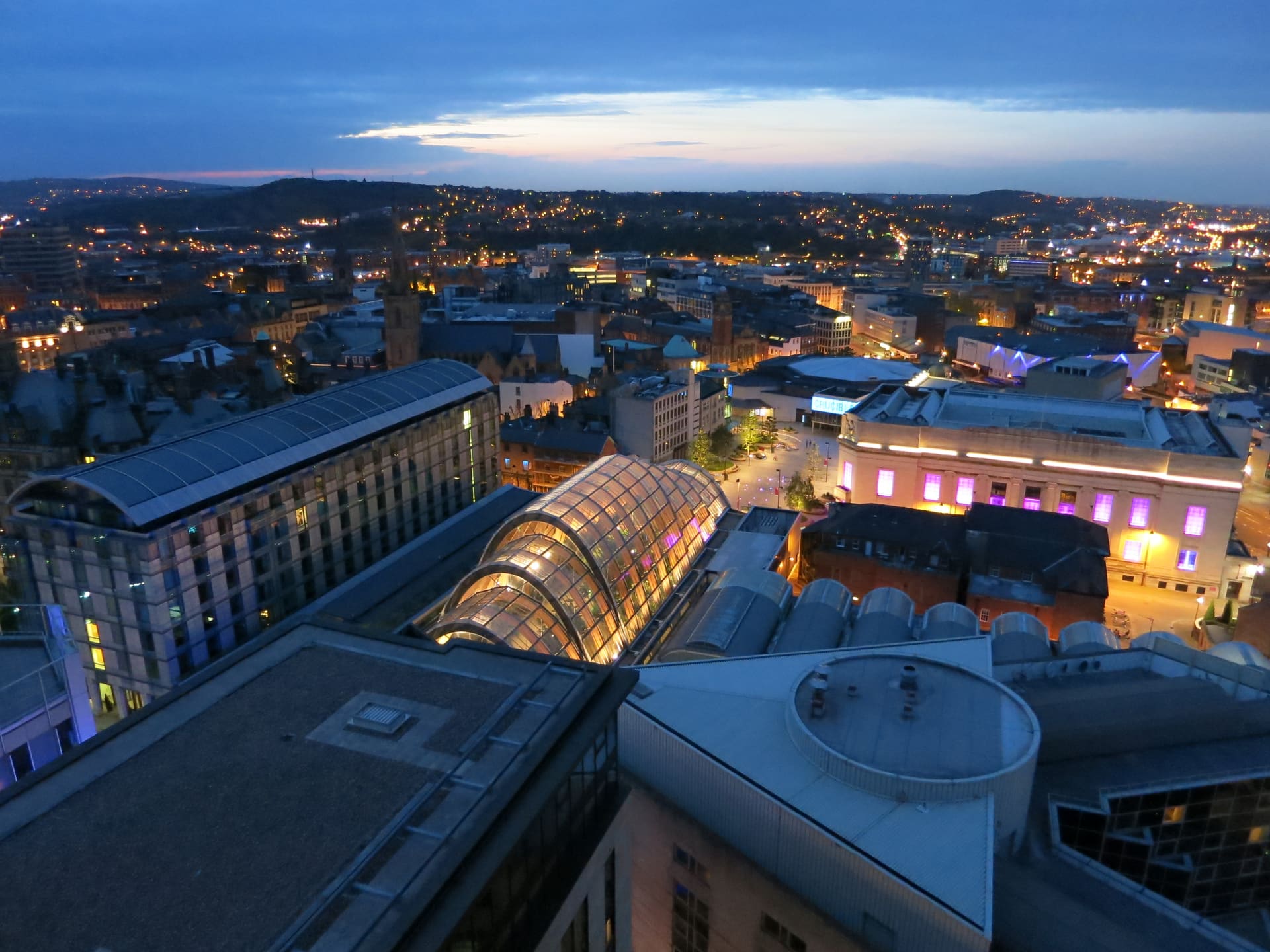 Sheffield's lit city centre at night, the Winter Garden glass below.